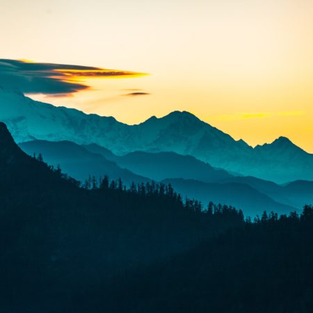 silhouette of trees and mountains during sunset