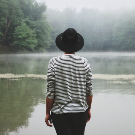person standing near swamp lake during daytime